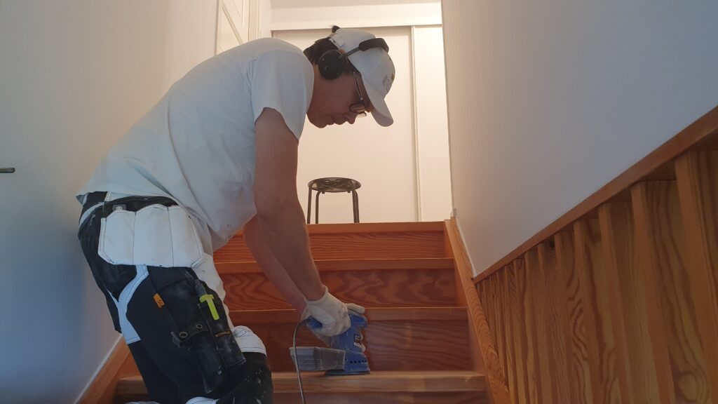 Sanding stairs before painting.